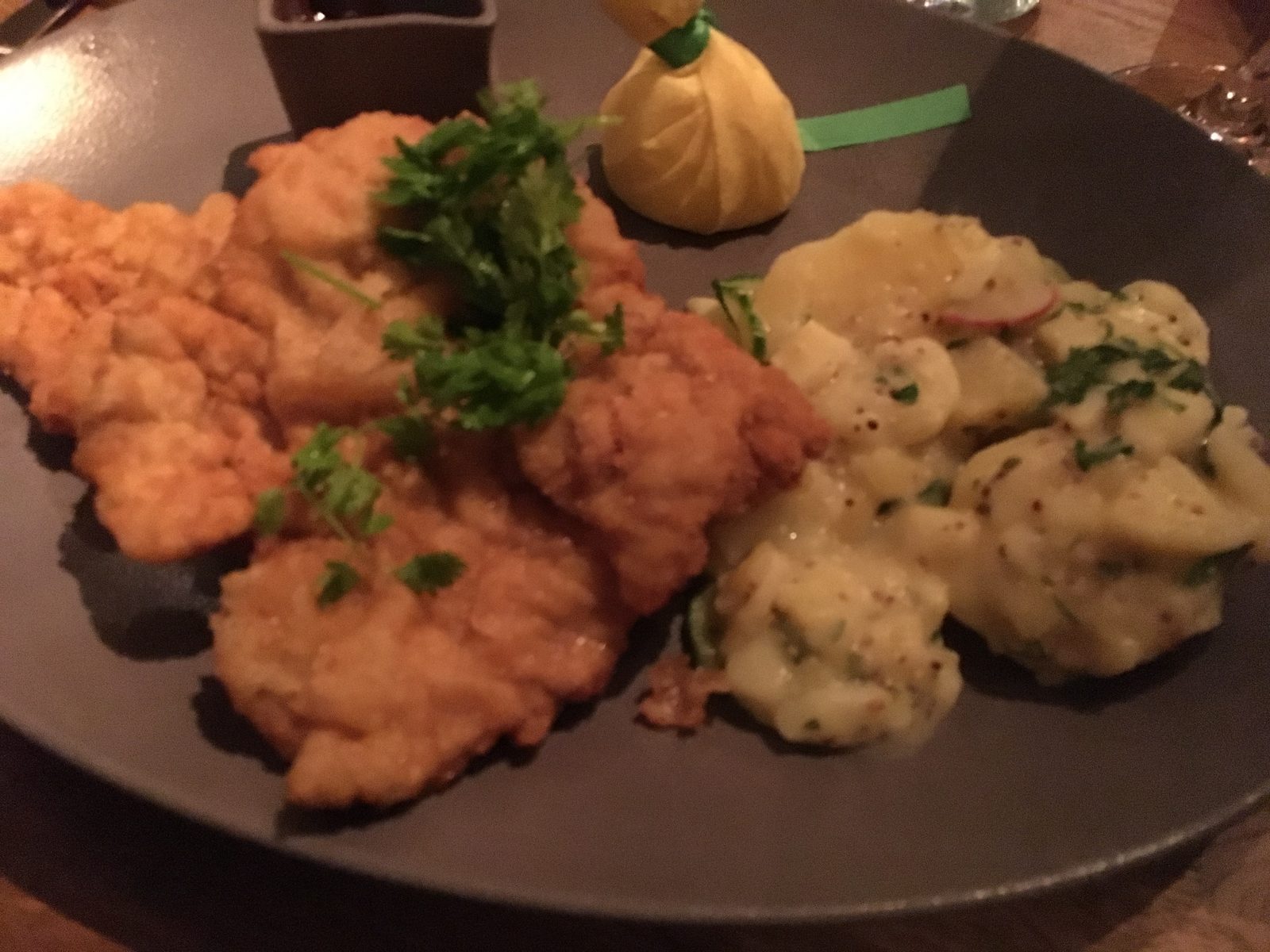 Wiener Schnitzel goldbraun gebacken, mit Kartoffel-Gurkensalat, Zitrone und Preiselbeeren