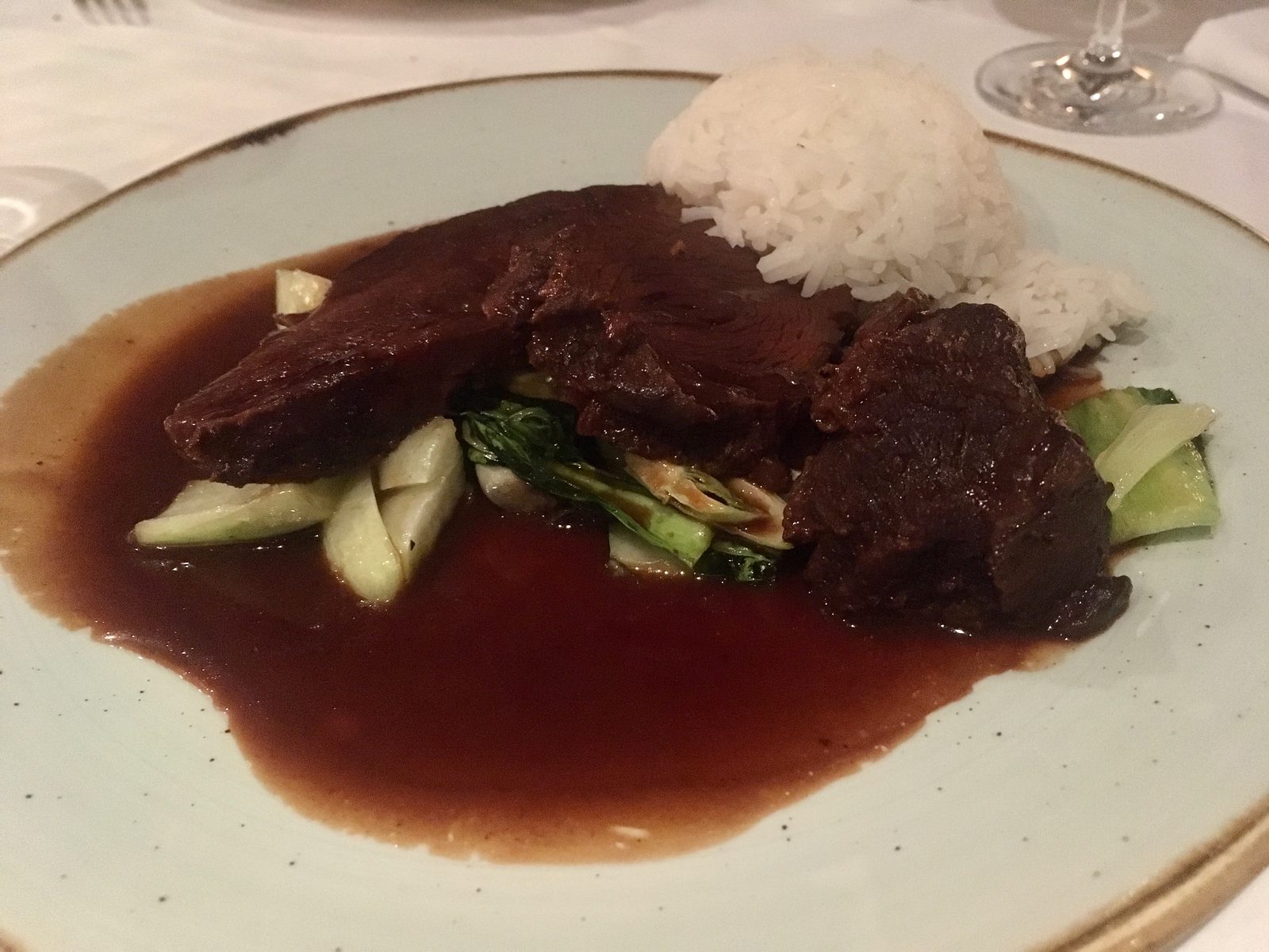 Ochsenbacke in asiatischem Sud, dazu Pakchoi und Duftreis